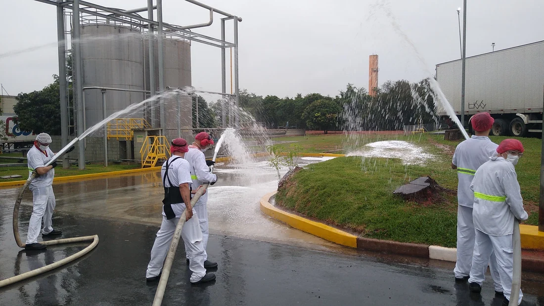 Treinamento com linha de mangueira em pátio de planta industrial