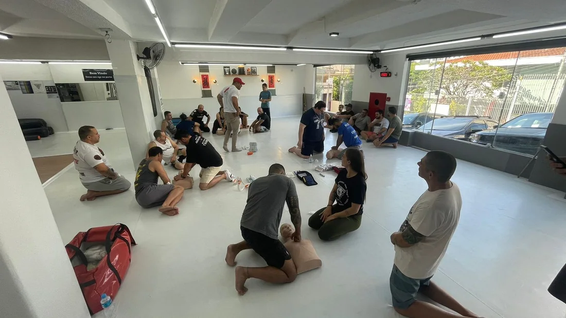 Turma praticando reanimação cardiopulmonar em manequins durante treinamento de primeiros socorros