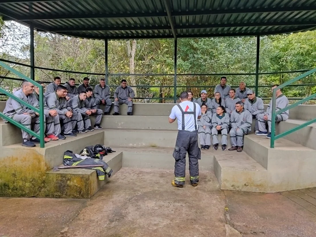 Turma reunida em arquibancada durante instrução teórica ao ar livre